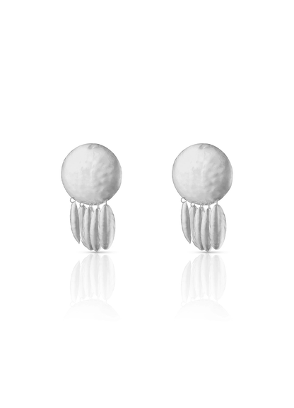 Aretes medianos en plateado con base circular repujada y colgantes ovalados a juego, una pieza de
diseño escultórico de Paula Mendoza.