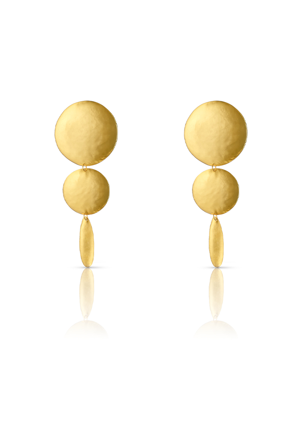 Aretes grandes y largos en dorado compuestos por dos círculos y un óvalo, todos con textura
repujada; una pieza de diseño escultórico de Paula Mendoza.