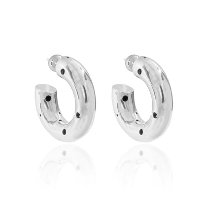 Aros gruesos de tamaño grande en plata con delicadas perforaciones y acabado pulido de alto brillo.